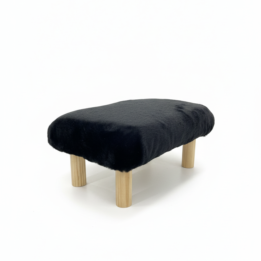 Handcrafted footstool with plush black faux fur top and natural wood legs. On a white background. Made by Little Forest Studio.