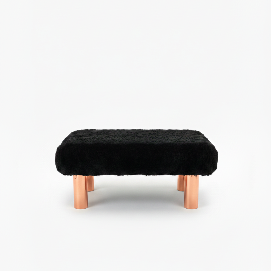 Handcrafted footstool with plush black faux fur top and copper wood legs. On a white background. Made by Little Forest Studio.