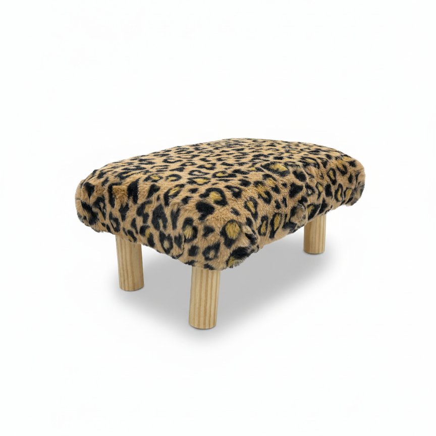 Handcrafted footstool with plush cheetah print faux fur top and natural wood legs. On a white background. Made by Little Forest Studio.