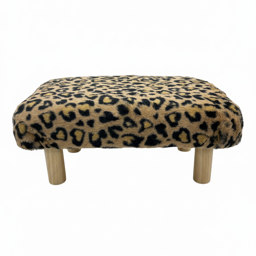 Handcrafted footstool with plush cheetah print faux fur top and natural wood legs. On a white background. Made by Little Forest Studio.