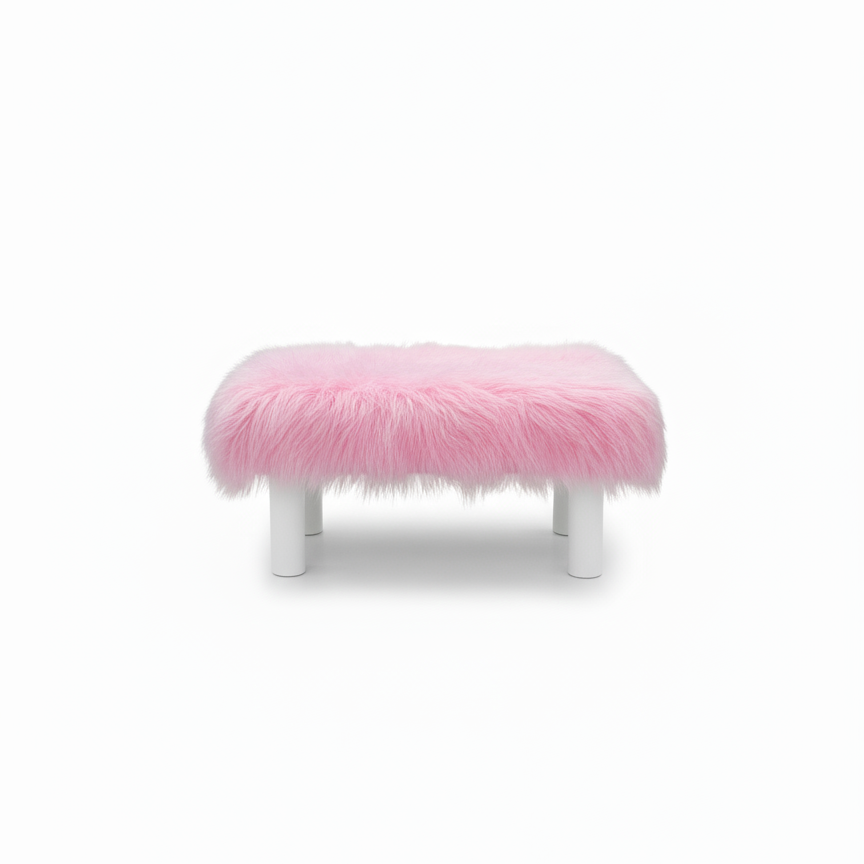 Handcrafted footstool with plush light pink shaggy faux fur top. It has wooden white legs. On a white background. Made by Little Forest Studio