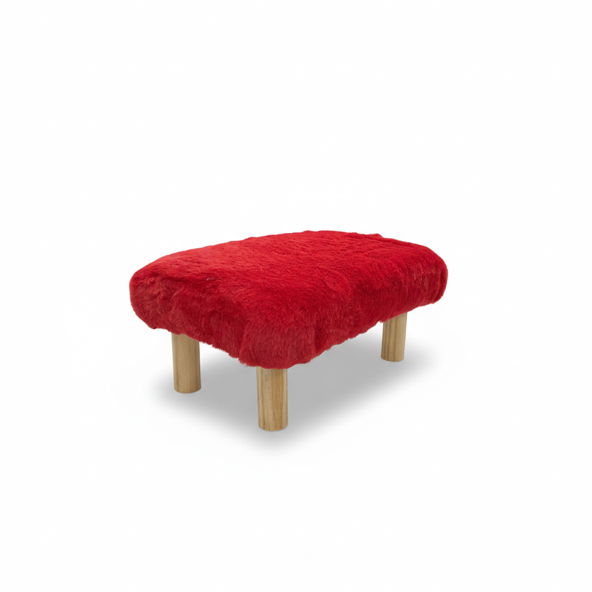 Handcrafted footstool with plush red faux fur top. It has natural colored wood legs. On a white background. Made by Little Forest Studio.