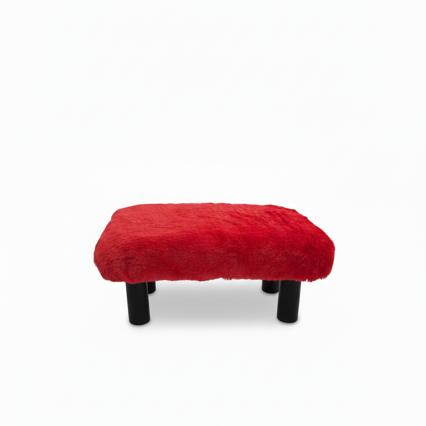 Handcrafted footstool with plush red faux fur top. It has black wood legs. On a white background. Made by Little Forest Studio.