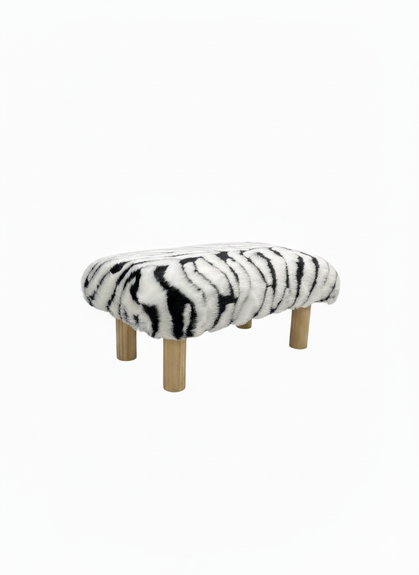 Handcrafted footstool with Zebra print faux fur top and natural wood legs. On a white background. Made by
Little Forest Studio.
