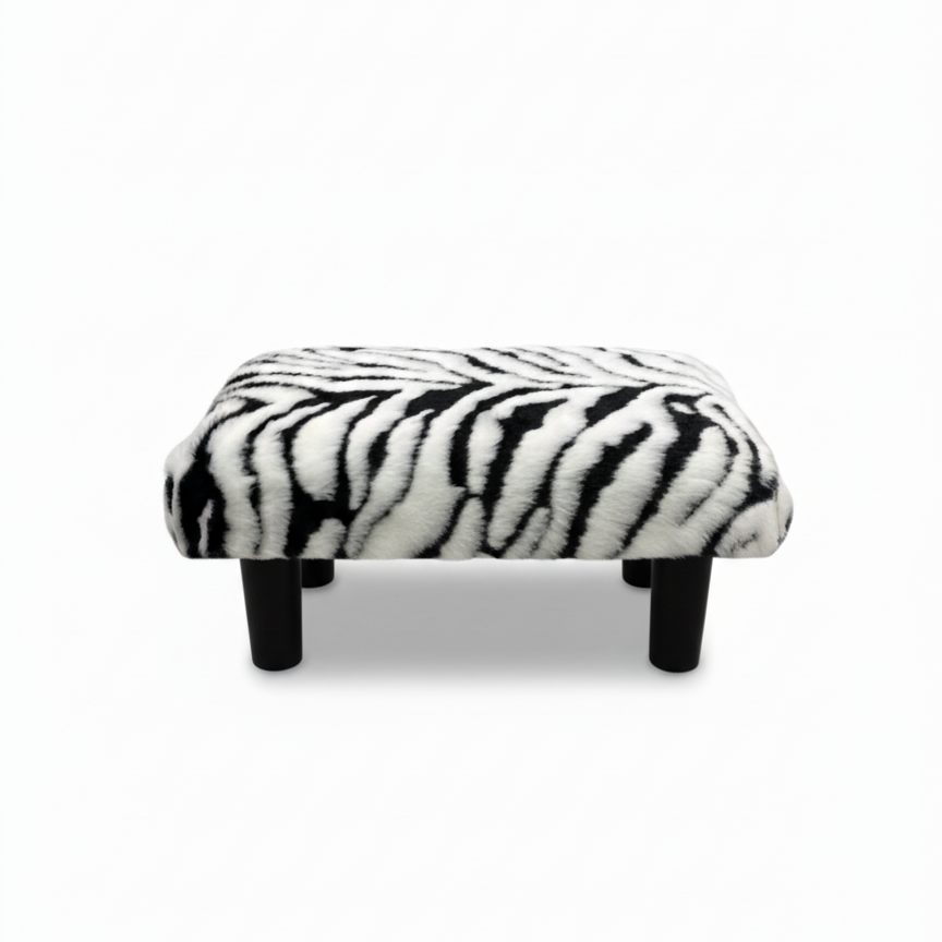 Handcrafted footstool with Zebra print faux fur top and black wood legs. On a white background. Made by Little Forest Studio.