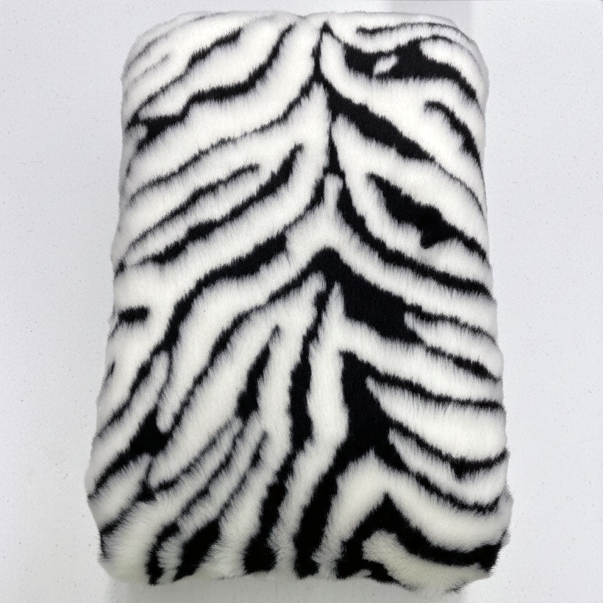 Handcrafted footstool top with a Zebra print faux fur. On a white background. Made by Little Forest Studio